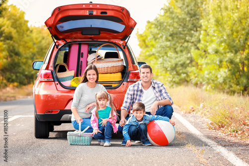 Happy family near car on th...