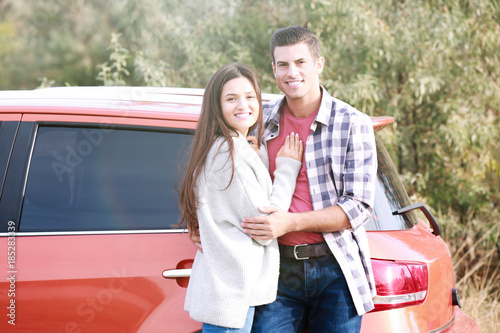 Young couple near modern ca...