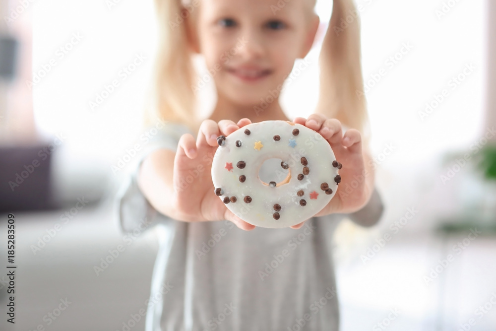 Little girl with sweet donut in room Little girl with sweet donut in room