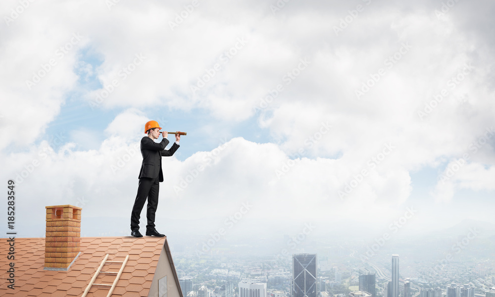 Engineer man standing on roof and looking in spyglass. Mixed media Engineer man standing on roof and looking in spyglass. Mixed media