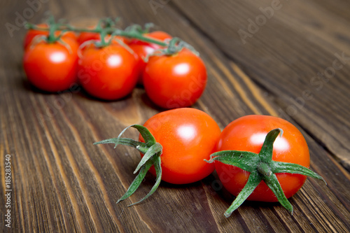 Ripe tomatoes on dark wooden background