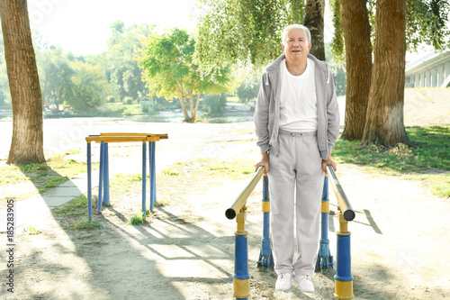 Fototapeta Naklejka Na Ścianę i Meble -  Mature man doing exercise in park