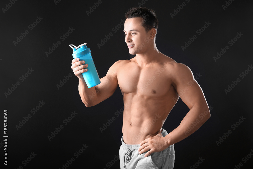 Sporty young man with protein shake on black background Sporty young man with protein shake on black background
