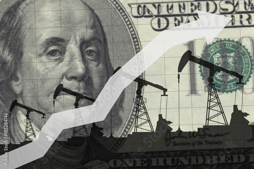 Oil pumps on the background of 100 dollars.Oil industry concept. Raising prices chart photo