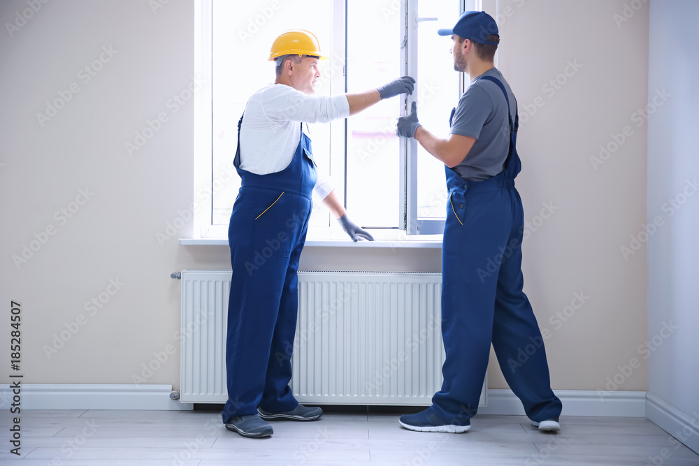 Window Operative Construction Construction worker with trainee installing window in house Stock Photo ...