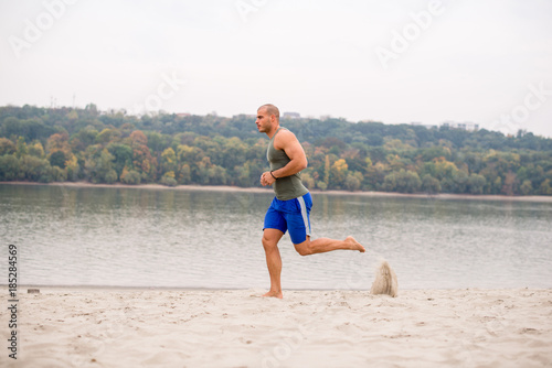 Portrait of man running on sand.