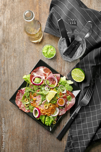 Plate with delicious fresh salad on table