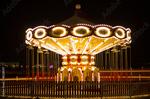 vintage carousel decorated with bright lights in the winter night