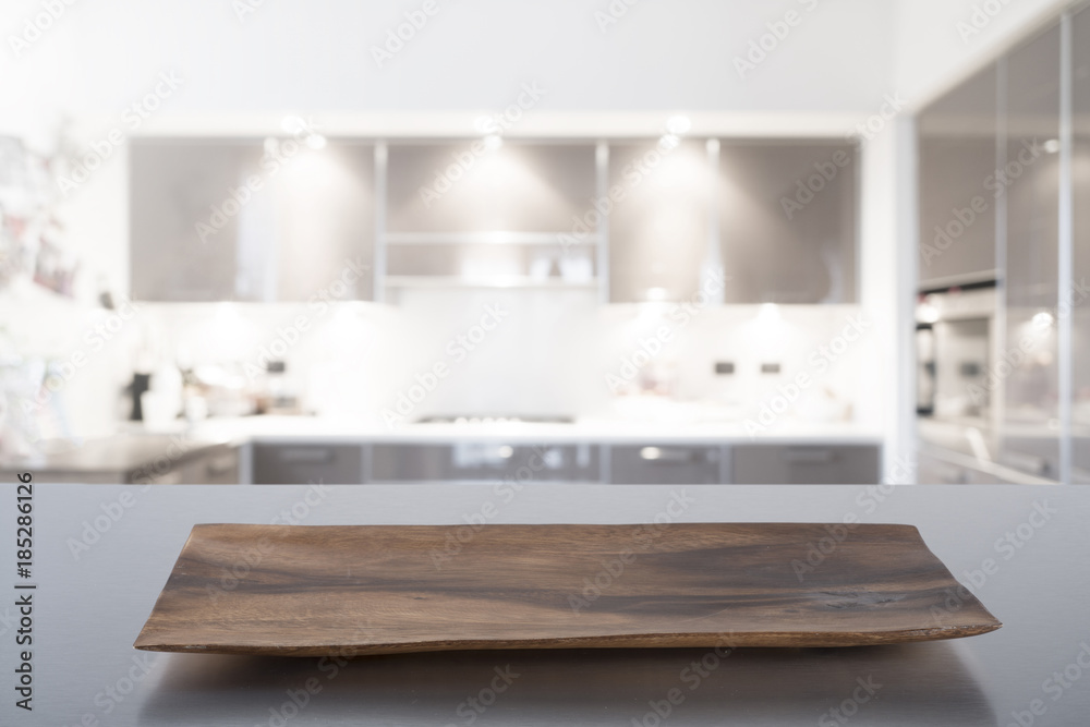 Empty cutting board on steel table with blurred modern kitchen background. Ready for product montage. Empty cutting board on steel table with blurred modern kitchen background. Ready for product montage.