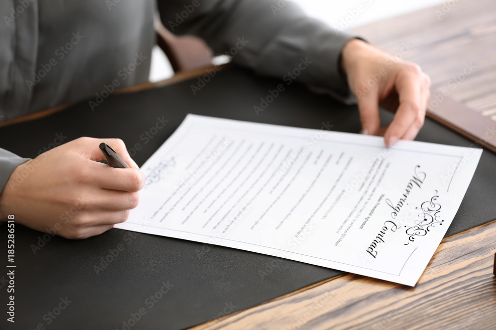 Female notary signing marriage contract, closeup Female notary signing marriage contract, closeup