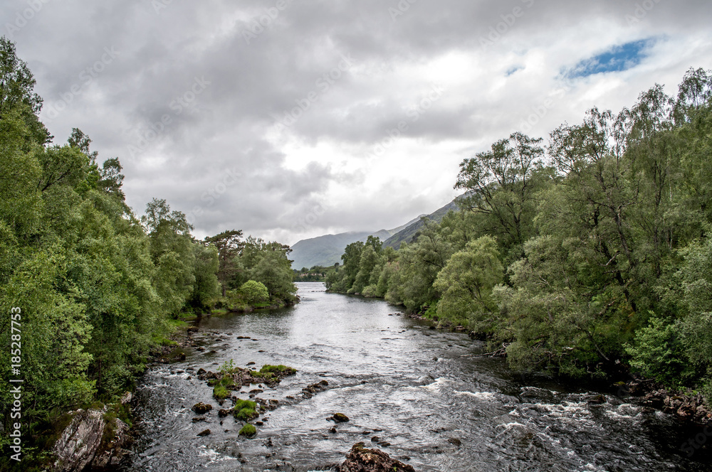 A valley with river-lined trees in the Scottish area called Glen Afric