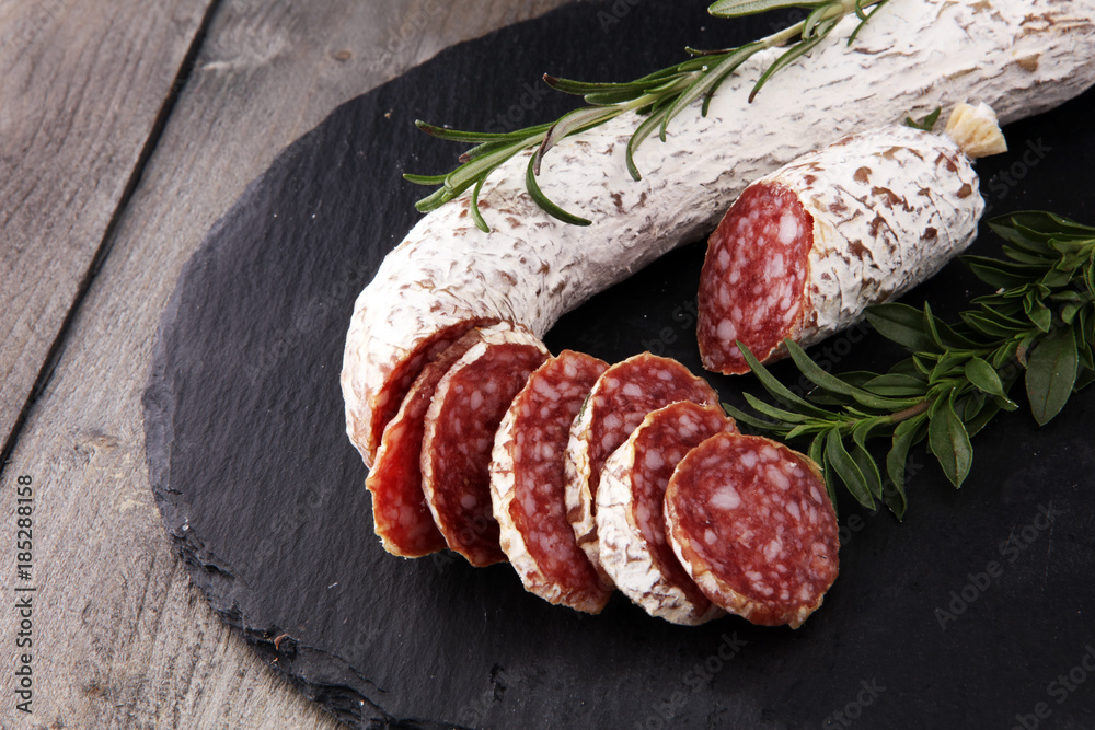 Stone cutting board with sliced salami on it Stone cutting board with sliced salami on it
