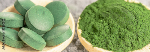 Chlorella, spirulina green algae in powder and tablets form- closeup, macro shot