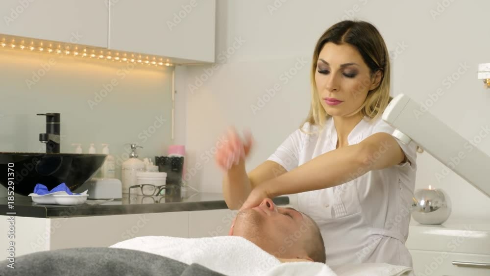 Cosmetologist is doing procedure of face massage for young boy / man. Model, close-up. Cosmetological clinic. Healthcare Cosmetologist is doing procedure of face massage for young boy / man. Model, close-up. Cosmetological clinic. Healthcare