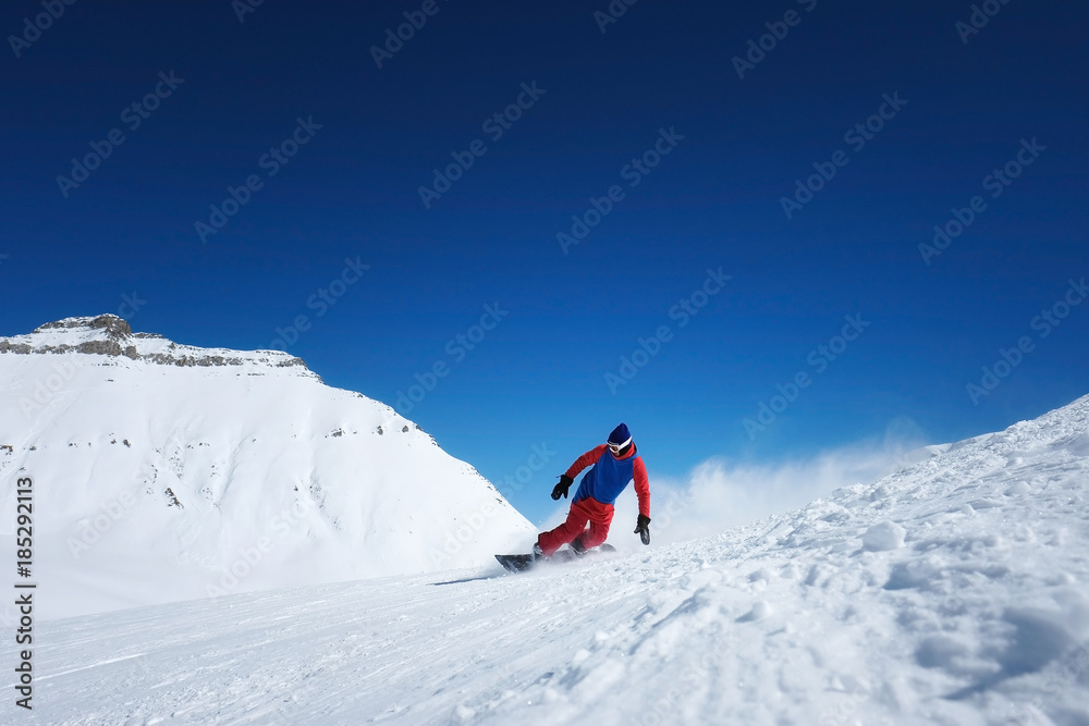 Stylish male athlete snowboarder rides on a blackboard on the snow
