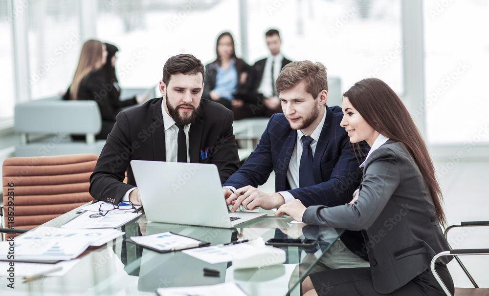 confident business team working on laptop with financial records confident business team working on laptop with financial records