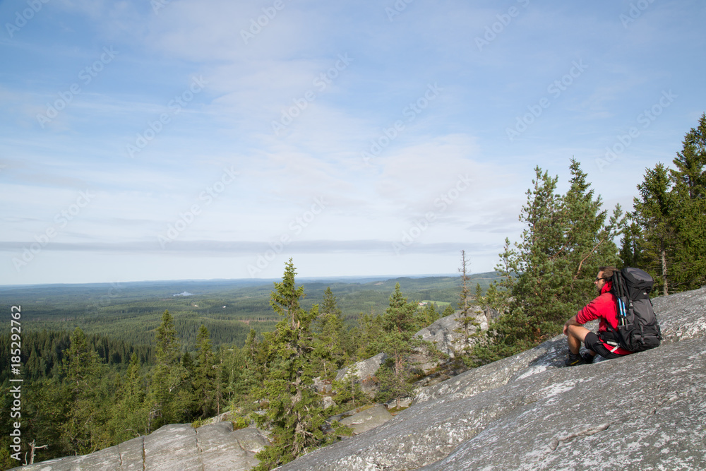 Hiker sitting on the summit Akka-Koli and enjoys the natural landscape, summer 