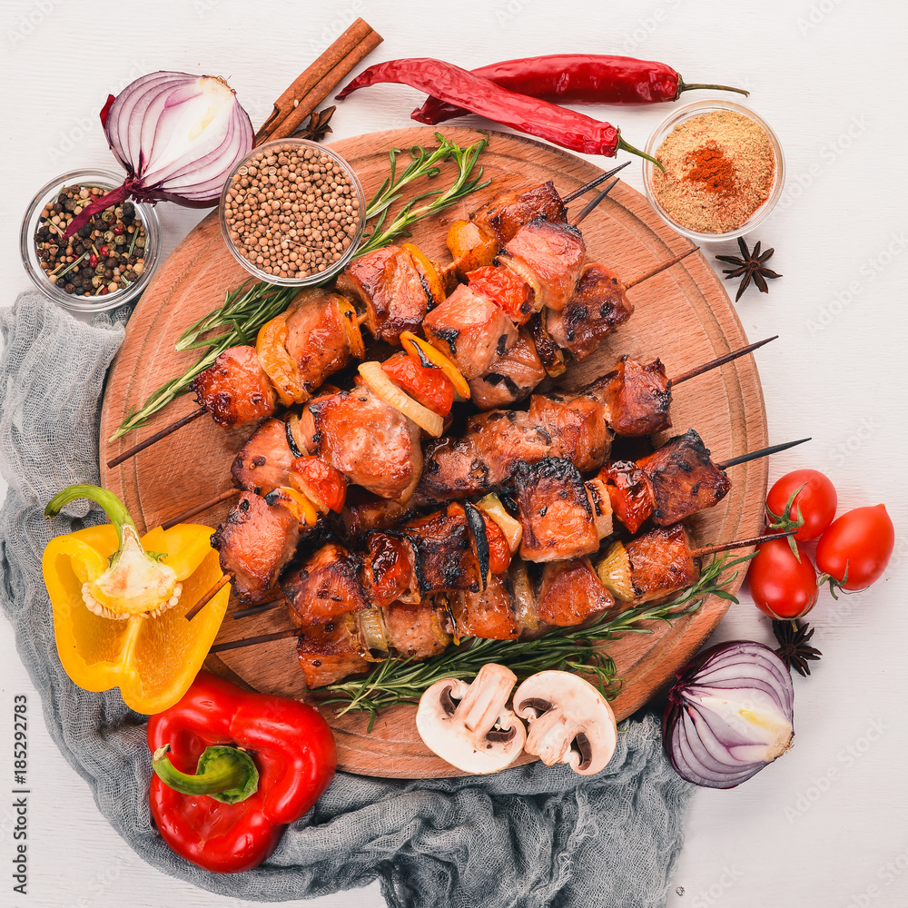 Marinated baked kebab with onions and spices. On a wooden background. Top view. Free space for text. Marinated baked kebab with onions and spices. On a wooden background. Top view. Free space for text.