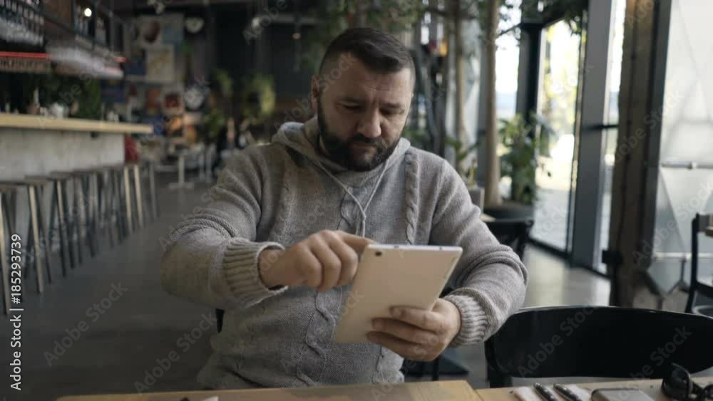 Young man with tablet computer in cafe in the city
Young man with tablet computer in cafe in the city