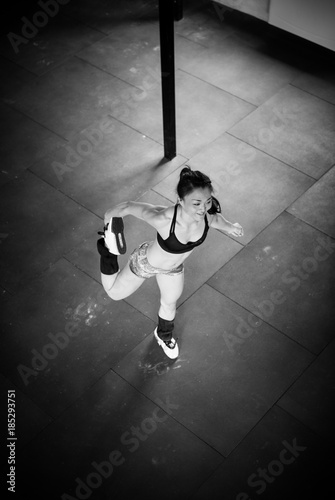 Girl is stretching leg standing, b&w