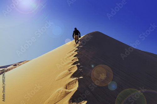 A man walking along the ridge of the Singing Barkhan. Nature reserve Altyn Emel. Kazakhstan photo