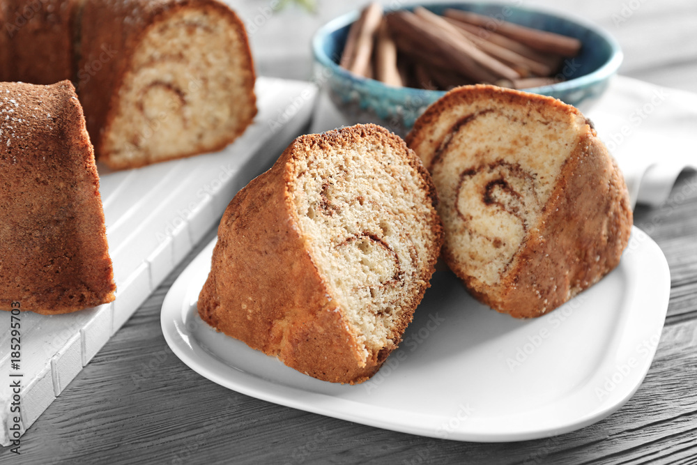 Plate with delicious cinnamon roll cake on table Plate with delicious cinnamon roll cake on table