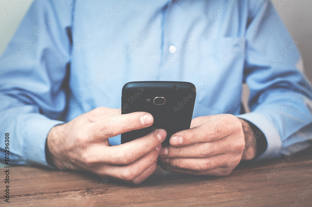 Businessman using smartphone in his desk. Businessman using smartphone in his desk.