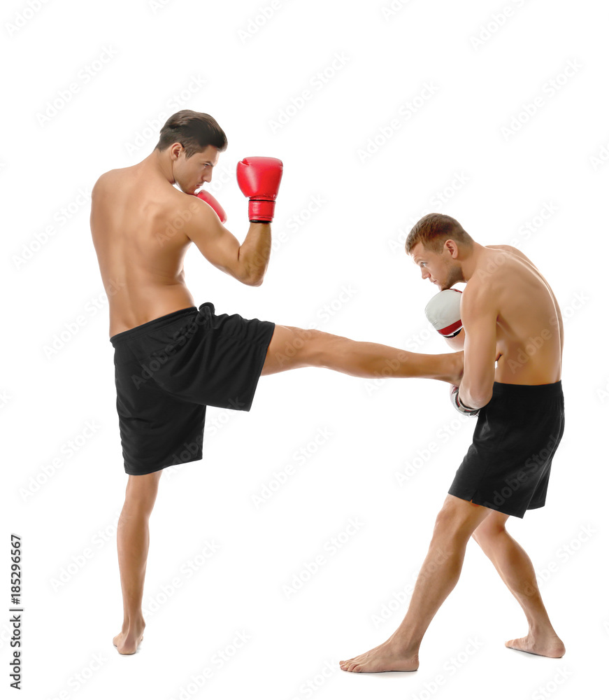 Attractive young kickboxers fighting on white background Attractive young kickboxers fighting on white background