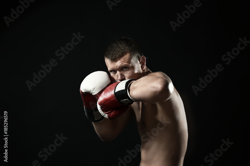 Attractive young boxer on black background © Africa Studio