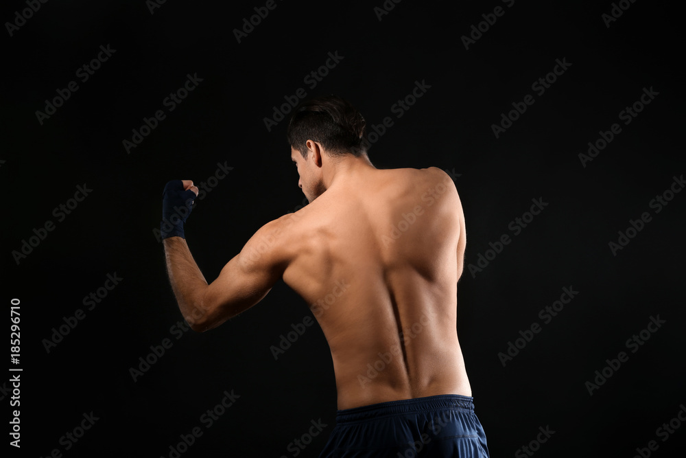 Attractive young boxer on black background