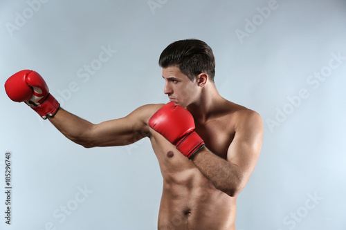 Attractive young boxer on light background