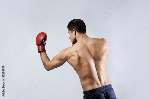 Attractive young boxer on light background © Africa Studio