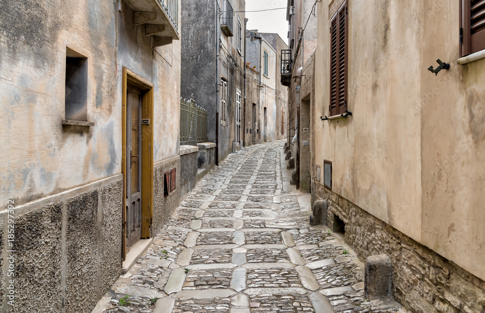 Typical narrow stone street in the medieval historical center of Erice, province of Trapani in Sicily, Italy