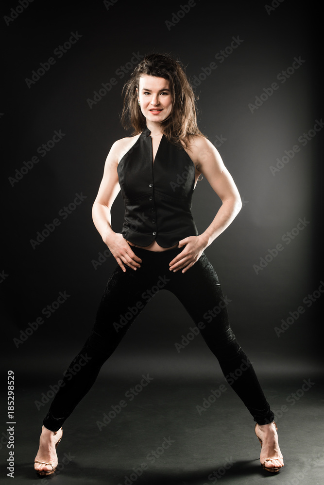 Beautiful model in black clothes against dark background