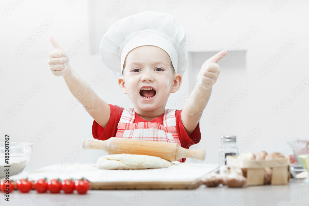 Boy with chef hat preparing the pizza dough Boy with chef hat preparing the pizza dough