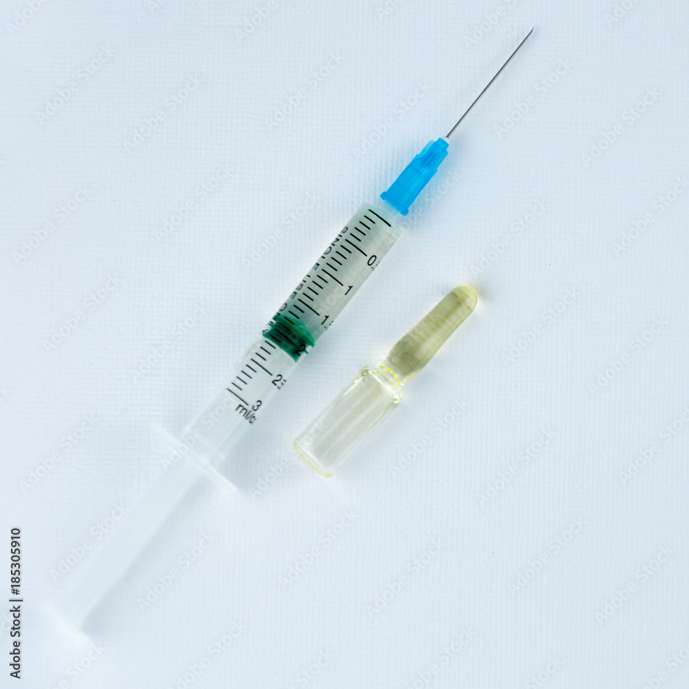 Syringe and small ampoules with medicine on a light background. Syringe and small ampoules with medicine on a light background.
