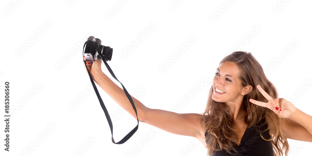 Pretty happy girl taking a selfie with a vintage camera; isolated on white, customizable background with copy space Pretty happy girl taking a selfie with a vintage camera; isolated on white, customizable background with copy space