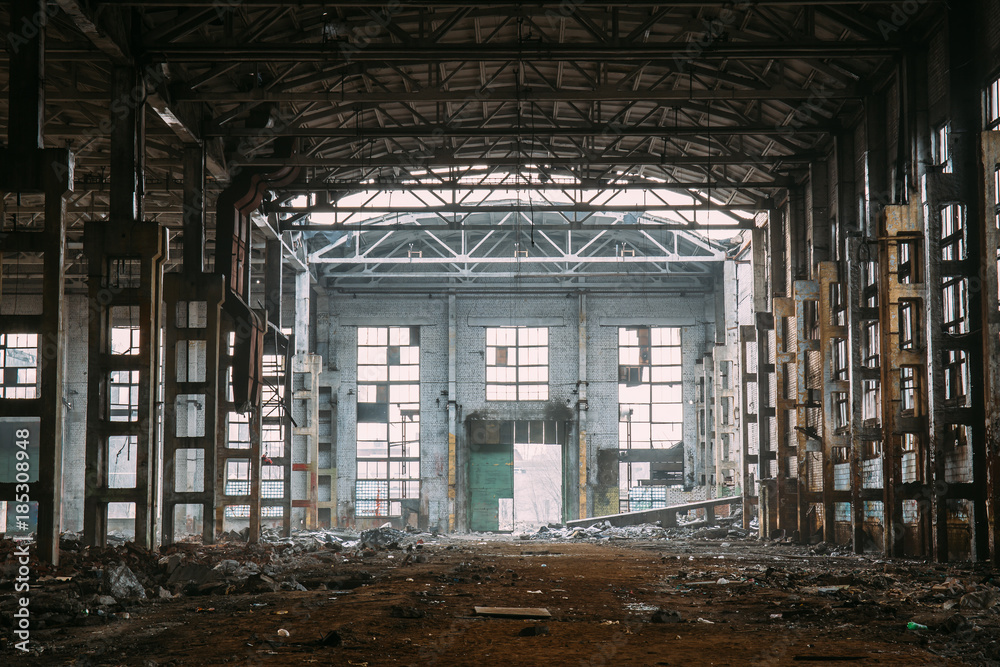 Dark creepy ruins of demolished abandoned large industrial warehouse or hangar of Soviet factory