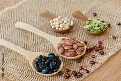 Different dried legumes on wooden spoon, Prepared dried bean for cooking