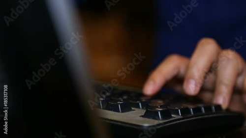 Man's hands are typing on the keyboard of desktop computer