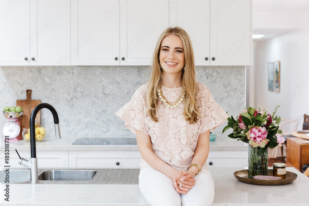 Portrait of an interior designer sitting on a kitchen bench Portrait of an interior designer sitting on a kitchen bench