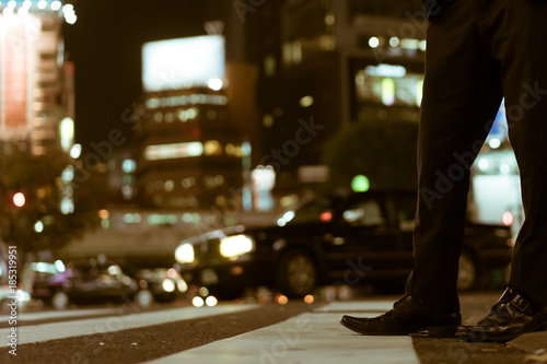 Busy businessman legs waiting to cross the famous Shibuya Crossing, Tokyo, Japan