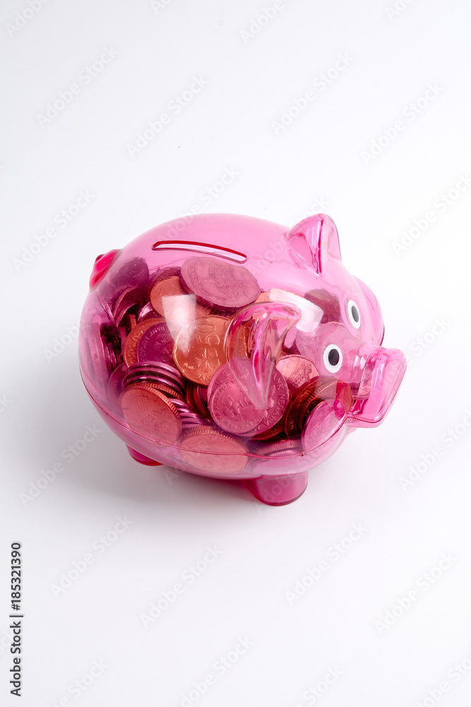 Naklejka premium Coins in the red piggy bank isolated on white. Saving and investment conceptual.