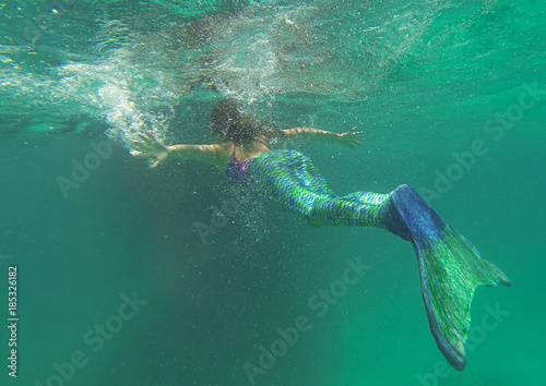 Mermaid in the sea  beautiful blond woman with fish mermaid tail swimming underwater in the blue green ocean water  beauty and nature  awesome people  creative picture