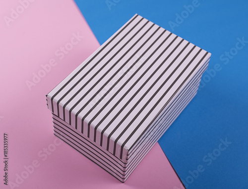 White shoe box with black stripes on pink and blue background. Mockup.
