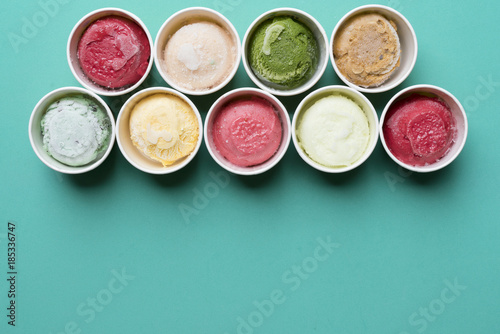 Top view Ice cream flavors in cup on green background