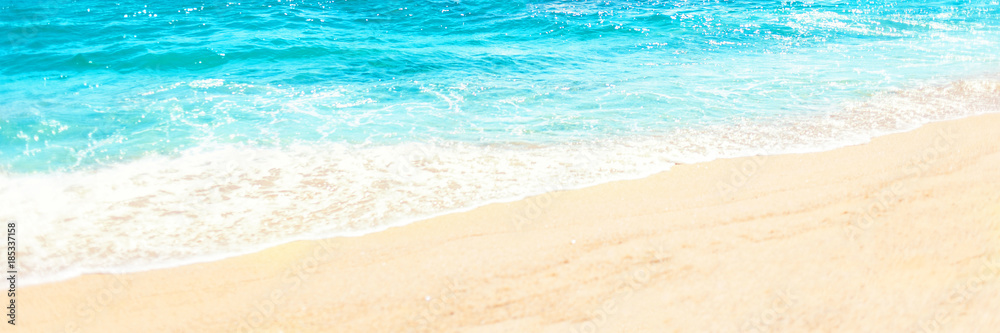 Soft wave of blue ocean on sandy beach Background with place for text. Tropical summer vacation concept. Soft wave of blue ocean on sandy beach Background with place for text. Tropical summer vacation concept.