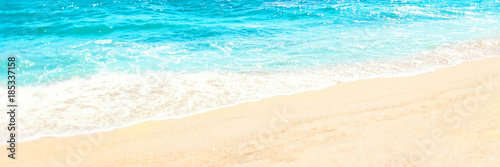 Soft wave of blue ocean on sandy beach Background with place for text. Tropical summer vacation concept.