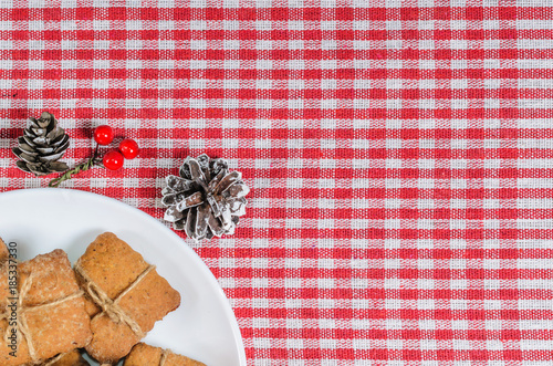 Cookies and Christmas decor on a red napkin top view