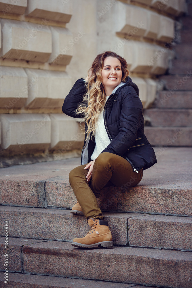 Beautiful elegant woman standing in a park in autumn
